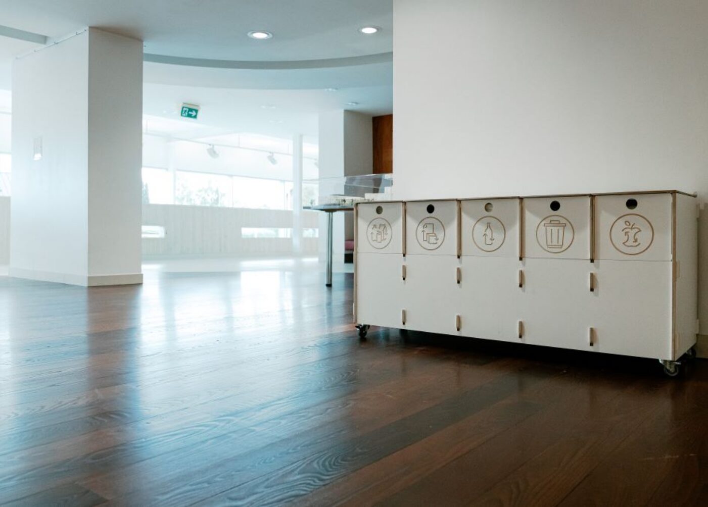 Recycling bins for office corridors placed along a hallway to support quick and intuitive waste sorting.