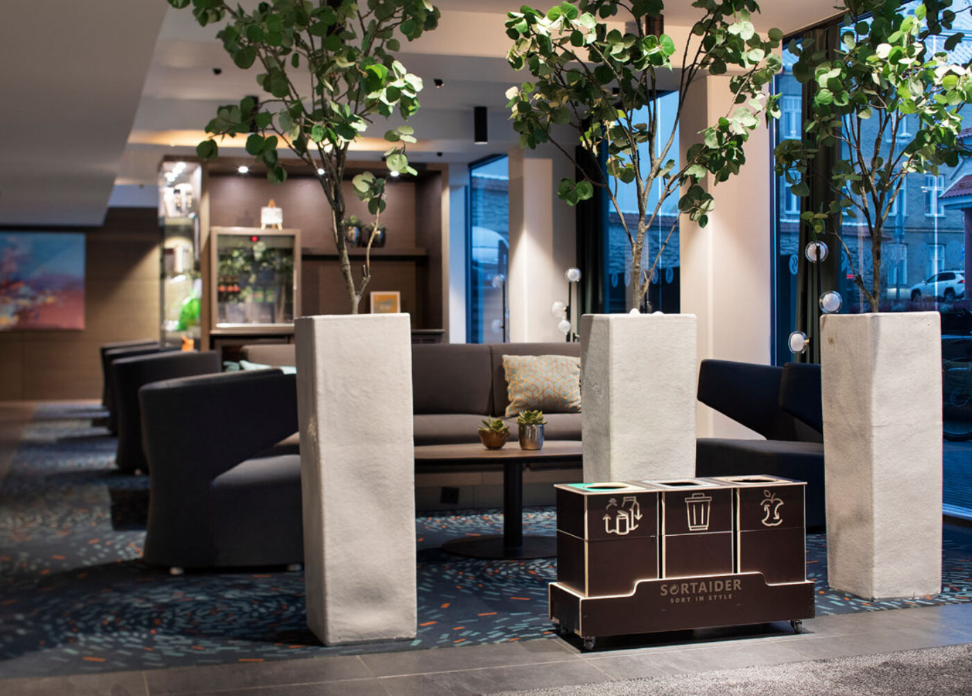 Recycling bins for sustainable offices placed in a shared workspace to make waste sorting feel effortless.