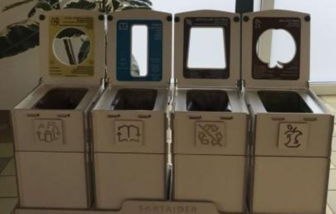 Recycling bins and four-section waste sorting stations in classrooms, designed for kids to separate bio-waste, paper, packaging, and general waste.